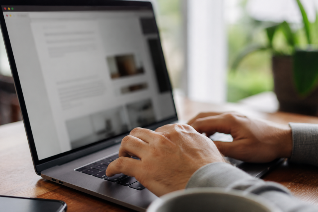 Person typing on a laptop while editing website content in a web browser.